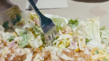 Bir çatalın yakın çekimi, Sezar salatasından bir ısırık, marul, tavuk, kızarmış ekmek, peynir ve kremalı sos.