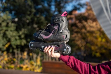 Parkta paten tutan bir kadın güneşli bir günde paten yapmaya hazırlanıyor.