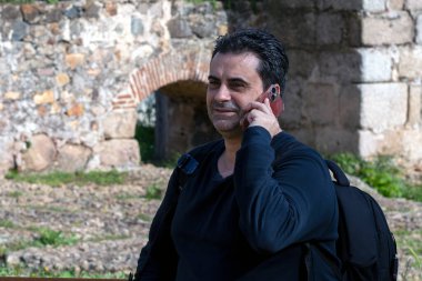 Genç Adam Akıllı Telefon ve Siyah Sırt Çantası ile Konuşuyor