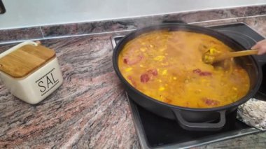 Güveçte paella hazırlayan kadın.