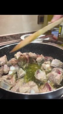 Tavada kaşık ile karıştırılmış pirzola.