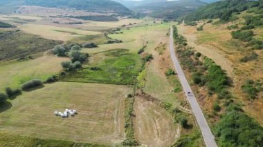 Yemyeşil kırsal alanlarda dolambaçlı bir yolun havadan görünüşü