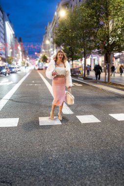 Modadan etkilenen biri, Granda caddeyi geçiyor, Madrid, alacakaranlıkta.