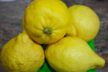 Saplı canlı sarı limonlar. Tazeliklerini ve kullanıma hazır olduklarını gösteriyorlar.
