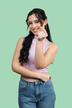 Neşeli genç bir kadın Kore 'nin el hareketleriyle sevgi ve sevgiyi sembolize ediyor.