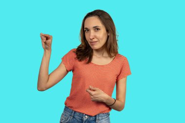 İki eli turkuaz arka planda parmaklarını şaklatan genç bir kadın.