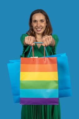 Alışveriş torbası tutan kadın, gökkuşağı tasarımı olan, çeşitliliği ve perakende satışını destekleyen.
