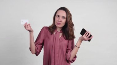 İş kadını, beyaz arka planda izole edilmiş online alışveriş için kredi kartı ve akıllı telefon sunuyor.