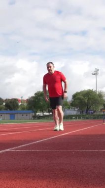 Koşu pistinde koşan olgun bir sporcu.