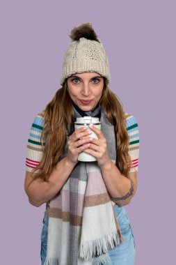 Stüdyoda, elinde tekrar kullanılabilir kahve fincanı tutan ve gülümseyen bir kadının portresi.