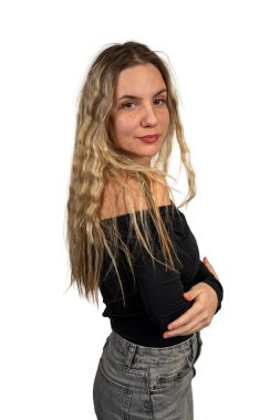 Genç bir kadın özgüvenle beyaz bir arka plana poz veriyor.