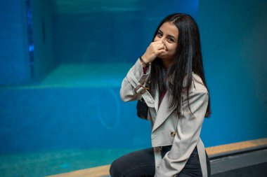 Turist burnunu büyük akvaryum tankından gelen kötü koku yüzünden tutuyor.