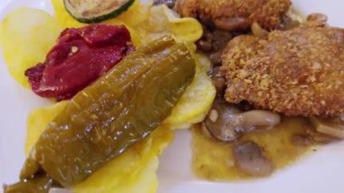 Kızarmış patates, biber, kabak ve mantar sosuyla servis edilen nefis kızarmış tavuk filetoları.