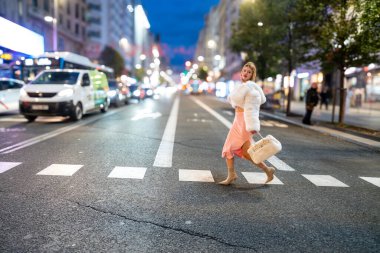 Gecenin bir yarısı şehir merkezinde yaya geçidinde yürüyen modacı.