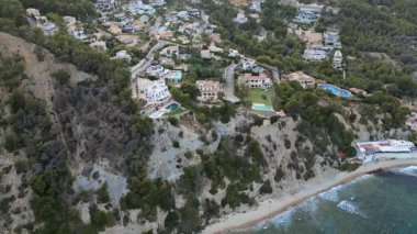 İnsansız hava aracı Akdeniz manzaralı bir uçurumun üzerinde uçuyor.