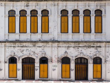 Kuala Lumpur 'daki eski bir binanın sokak pencereleri. Beyaz duvarlı sarı ahşap pencereler.
