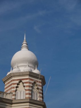 Tuğla fabrikası ve mavi gökyüzü olan beyaz kubbeli bir minare..