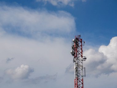 Bulutlu mavi gökyüzüne karşı çelik bir telekomünikasyon kulesi..