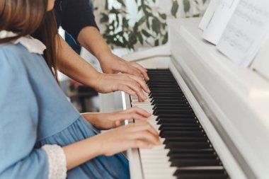 Bir yetişkin ve bir çocuk piyano çalıyor, eğitim konsepti