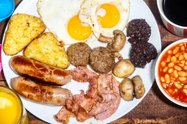 Pastırmalı, yumurtalı, sosisli ve kahveli İngiliz kahvaltısı.