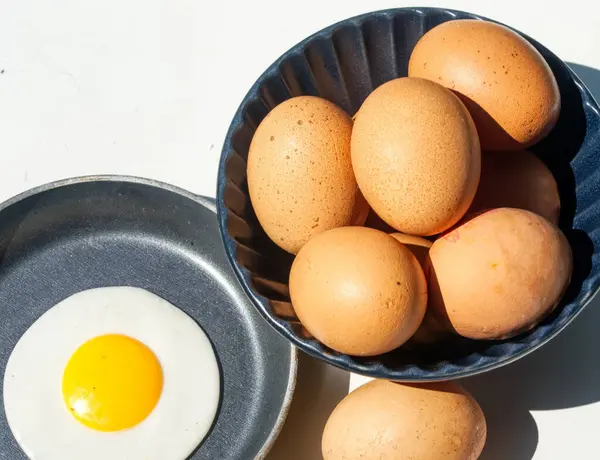 Beyaz arka planda tavada yumurtalar