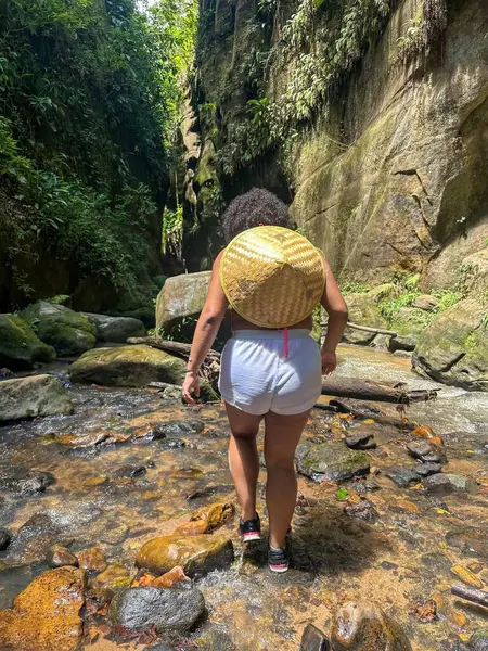 Bir kadın kaşif, yemyeşil kayalar ve yeşilliklerle çevrili dar bir kanyonda yürüyor. Nehir güneş ışığını yansıtırken, o büyük bir hasır şapka ve bir sırt çantası giyer. Sahne macerayı ve doğayla bağlantıyı aktarır..