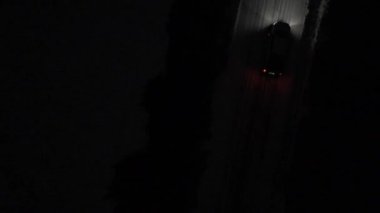 Bir kamyonetin hava görüntüleri gece karlı bir yolda ilerlerken çekiliyor. Farlar yanıyor, önümdeki yolu aydınlatıyor..