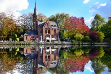 Minnewater park reflection on lake in Bruges, Belgium clipart