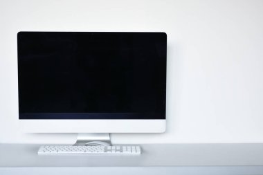 Ofis masasında fare ve klavye olan beyaz bilgisayar ekranı, beyaz arkaplan 