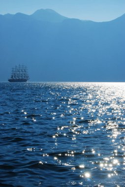 Sakin mavi dağ ve deniz manzarası Uzaklarda yelken açan büyük bir gemi