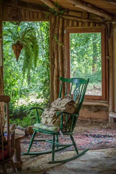 Tahta bir kulübede sallanan bir sandalyede bir sürü ev bitkisi olan sırt çantası.