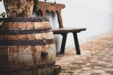 Eski ahşap fıçı ve şarap fabrikasının önünde bir bank.