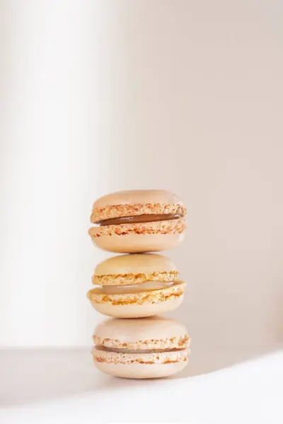 Üç yumuşak bej pastel makaron istiflenmiş.