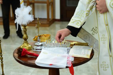 Rahip, kilisedeki vaftiz töreni için kutsal suyu kutsadı.