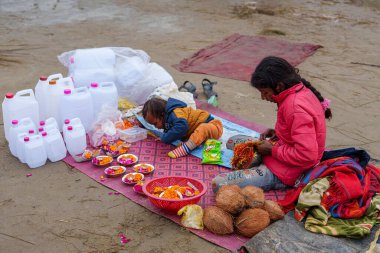  A little girl tending to her small shop at the Kumbh Mela, with her tiny sister by her side, radiating warmth and innocence in the vibrant, bustling spiritual gathering. clipart