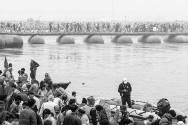 The bustling ghats of Triveni Sangam during Shahi Snan, with pilgrims taking their sacred dips in the Ganga, while police and safeguards maintain order amidst the massive crowd and the Polton bridges. clipart