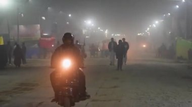 Prayagraj, Uttar Pradesh, Hindistan, 11 Ocak 2025. Seyyahlar Mahakumbh 'ın huzurlu yolları boyunca yürürler, sakin bir akşamda etraflarında yumuşak bir sis vardır..