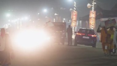 Prayagraj, Uttar Pradesh, Hindistan, 11 Ocak 2025. Dindarlar Mahakumbh 'da sisli bir akşamda gezinip huzurlu bir ruhsal atmosfer yakalıyorlar..