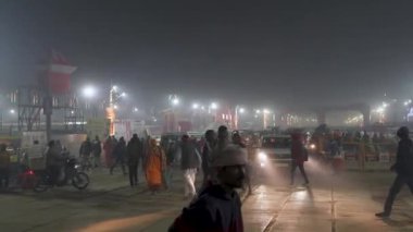 Prayagraj, Uttar Pradesh, Hindistan, 11 Ocak 2025. Mahakumbh fanatiklerinin sislerin arasında yürüyüp gecenin ruhani enerjisini kucakladıkları huzurlu bir sahne..