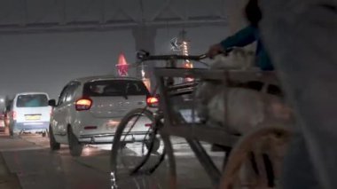 Prayagraj, Uttar Pradesh, Hindistan, 11 Ocak 2025. Kumbh Mela 'daki köprünün altında, hacılar hareketli bir caddeden geçerek büyük olay sırasında bir birlik ve bağlılık ortamı yaratıyorlar..