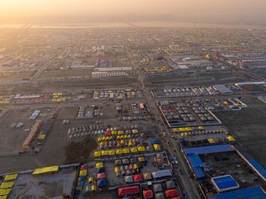 A stunning aerial view of Mahakumbh tent city at sunset, bathed in golden hues. The vast tents glow under the evening sky, creating a serene and spiritual ambiance over the sacred gathering. clipart