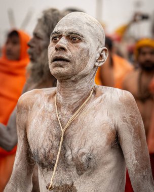 14 Ocak 2025, Prayagraj, uttar Pradesh, Hindistan. Yeni yapılmış Naga Sadhu, sırılsıklam ve kül içinde, Akhada 'ya doğru yürür, bakışları yoğun ve öteki dünyadandır..
