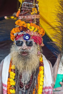 14 Ocak 2025, Prayagraj, uttar Pradesh, Hindistan. Deri kaplı bir Naga Sadhu, derin meditasyonda rudraksha mala kaldırıyor..
