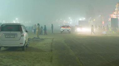 12 Ocak 2025, Prayagraj, uttar Pradesh, Hindistan. Yoğun sis örtüleri, sessiz gece sokakları, kutsal sislerin arasında yürüyen az sayıda dindar insan..