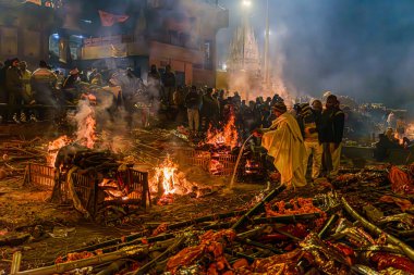 Varanasi, Uttar Pradesh, Hindistan, 28 Ocak 2024: Manikarnika Ghat 'taki alevler akşam havasında durmadan yanmakta, yaşam, ölüm ve ruhsal kurtuluşu sembolize etmektedir..