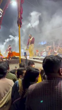 Varanasi, Uttar Pradesh, Hindistan, 28 Ocak 2024: Dashashwamedh Ghat 'ta rahipler Ganj Nehri' nin altın parıltısını yansıtırken senkronize bir bağlılık dansında gaz lambaları sallayarak kutsal Ganj Aarti 'yi icra ettiler..