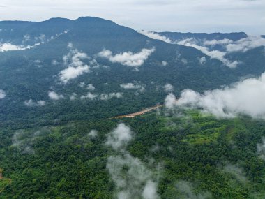 Muson sihri Khaddum Hillsan 'ın hava manzarasında yemyeşil yamaçlar yüzen bulutlar arasında kayboluyor, sakin ve manzaralı bir manzara..
