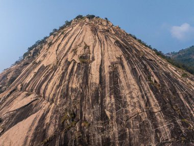 Pakhi Pahar, Purulia 'nın insansız hava aracı görüntüsü, boyanmış kaya yüzeyini yakalıyor ve yemyeşil yeşil alanı çevreleyerek doğa ve macera temalı projeler için ideal bir görüntü oluşturuyor..