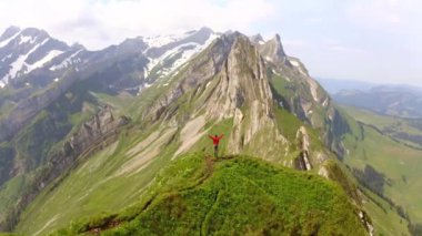 Yürüyüşçü muzaffer bir şekilde Alp Tepesi 'nde duruyor, Majestic Mountain Range Arkaplanı