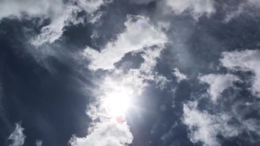 Parlak güneş dramatik, beyaz ve siyah bulutların arasından parlıyor.